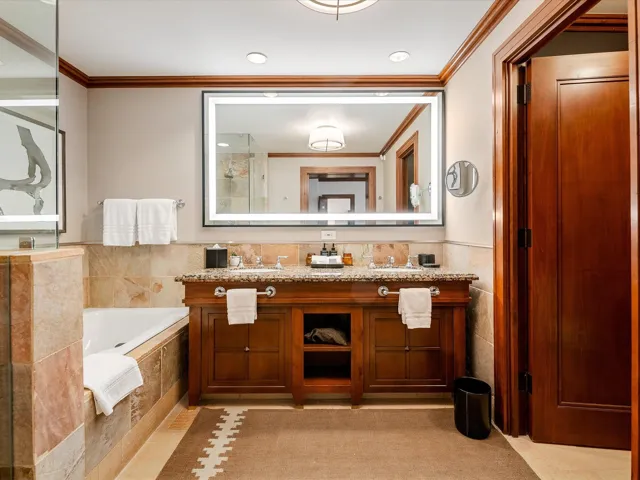 Full bathroom with crown molding, a bath, vanity, a shower, and tile walls