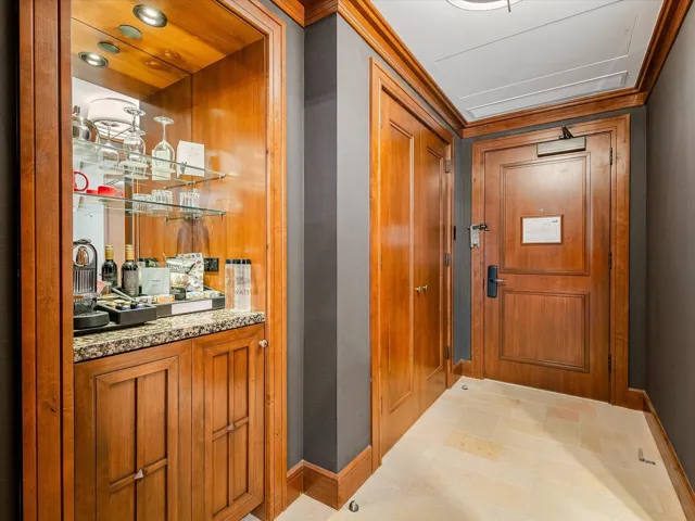 Entryway featuring crown molding, indoor bar, and baseboards