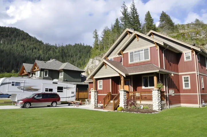 View of front of house with a front yard, covered porch, and a forest view