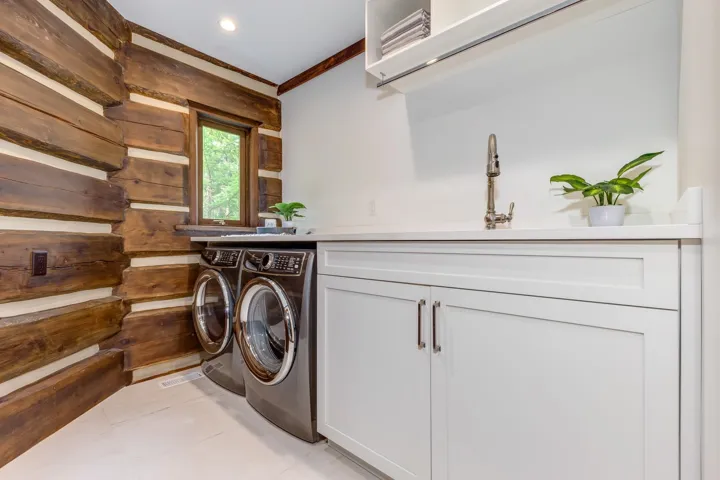 Laundry room with crown molding, light tile patterned floors, washer and clothes dryer, and cabinet space