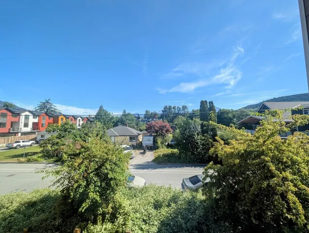 View of asphalt street featuring a residential view and curbs