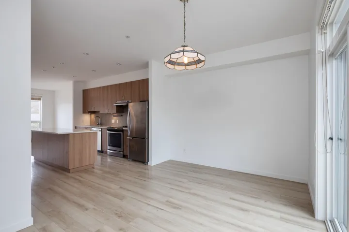 Kitchen featuring modern cabinets, light wood-style flooring, under cabinet range hood, appliances with stainless steel finishes, and light countertops