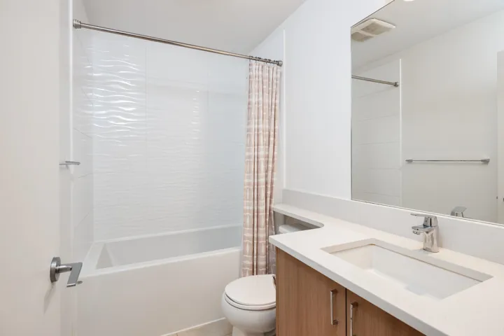 Full bathroom with visible vents, vanity, toilet, and shower / tub combo with curtain