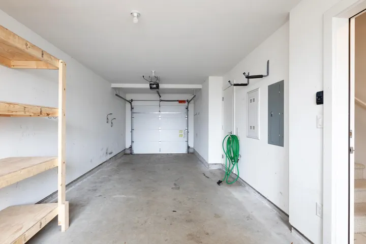 Garage with electric panel and a garage door opener