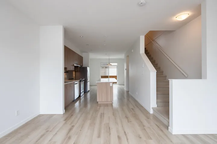 Kitchen with light wood-type flooring, modern cabinets, backsplash, light countertops, and dishwashing machine