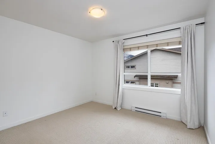 Spare room with carpet flooring, a baseboard heating unit, and baseboards