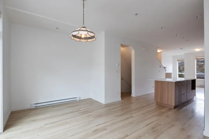Kitchen with modern cabinets, light wood-style flooring, a baseboard heating unit, a kitchen island, and hanging light fixtures