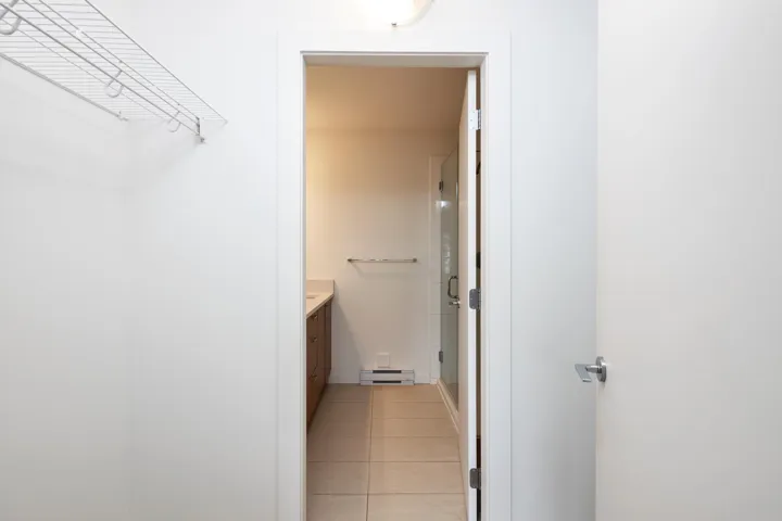 Bathroom with tile patterned floors, a baseboard radiator, a stall shower, and vanity