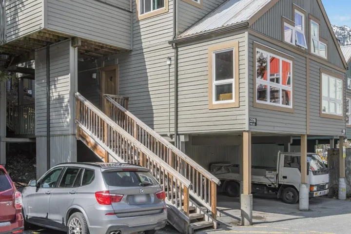 View of side of home featuring stairs and metal roof