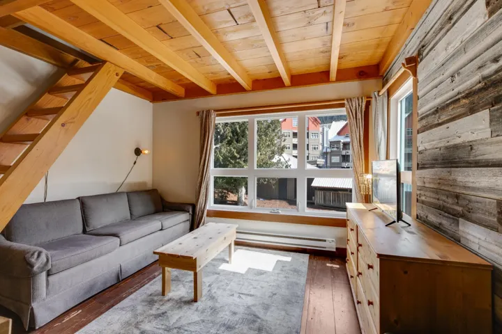 Living room with a baseboard radiator, wooden ceiling, hardwood / wood-style flooring, and beamed ceiling