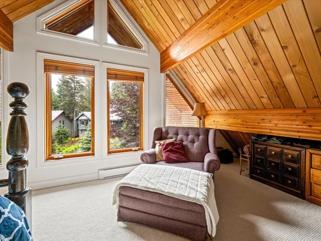 Bedroom featuring carpet floors, wood ceiling, and wood walls