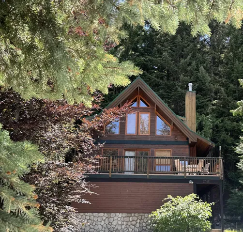Back of house with a chimney and a wooden deck