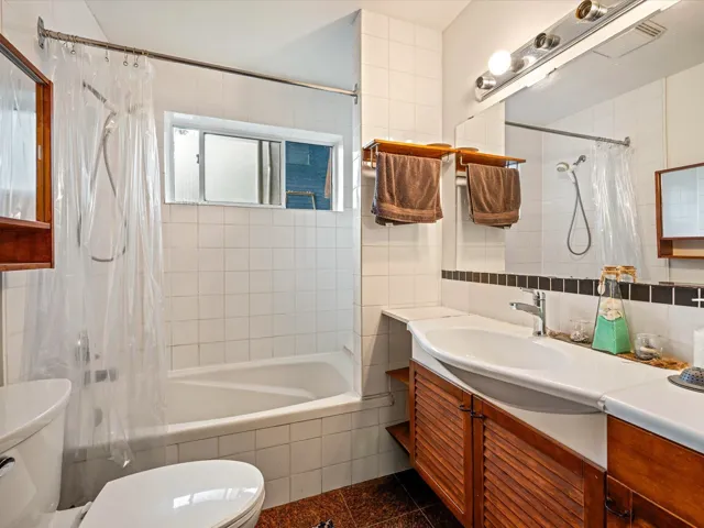 Full bathroom featuring vanity, tiled shower / bath combo, tile walls, and granite floors