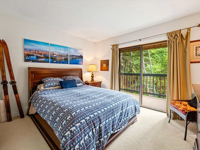 Carpeted bedroom with access to exterior and a water view