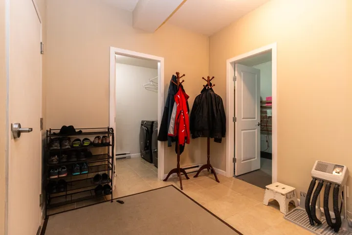 Hallway with washing machine and clothes dryer and a baseboard radiator
