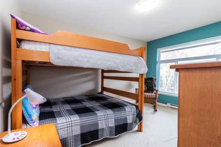 Bedroom featuring light carpet and a baseboard radiator