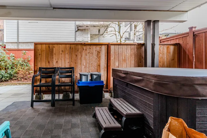 Fenced backyard featuring a hot tub and a patio area