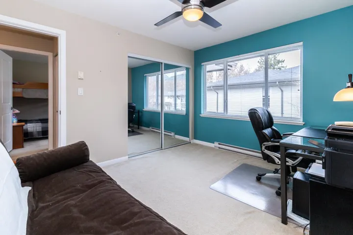 Office area featuring light carpet, a ceiling fan, and a baseboard heating unit