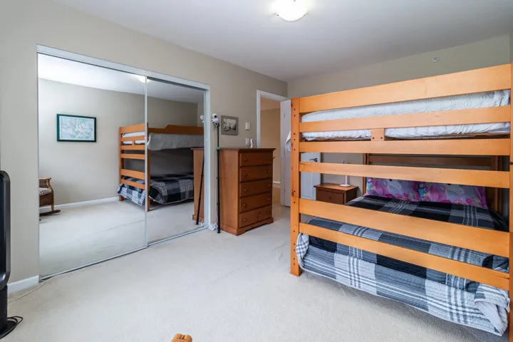 Bedroom featuring light carpet and a closet