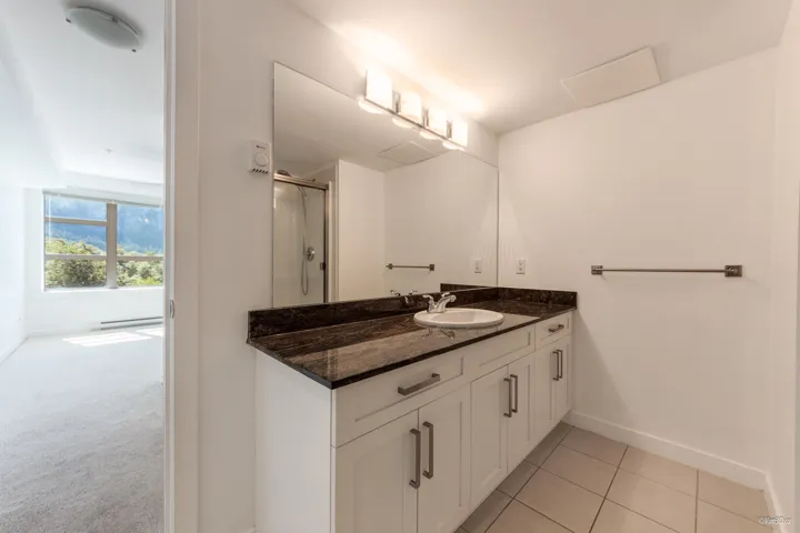 Bathroom with vanity, baseboards, an enclosed shower, and tile patterned floors