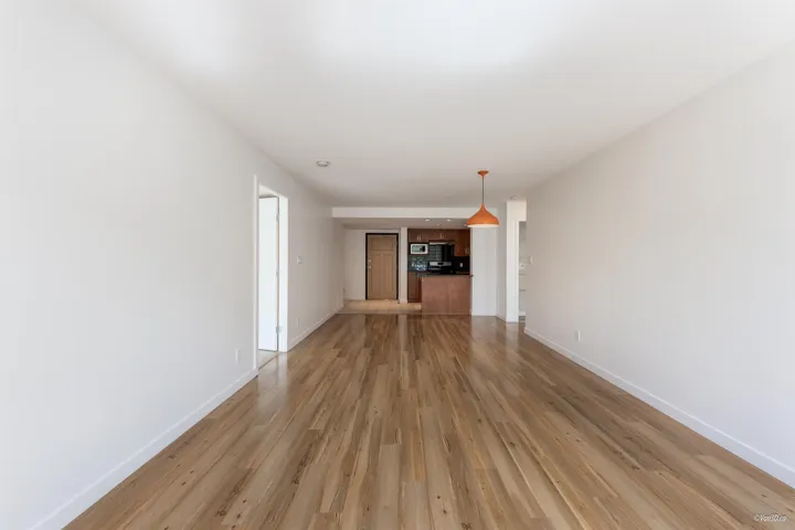 Unfurnished living room with baseboards and light wood finished floors