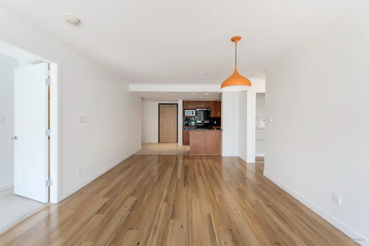 Unfurnished living room featuring light wood-style floors and baseboards