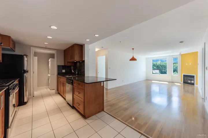 Kitchen featuring appliances with stainless steel finishes, brown cabinets, open floor plan, recessed lighting, and decorative backsplash