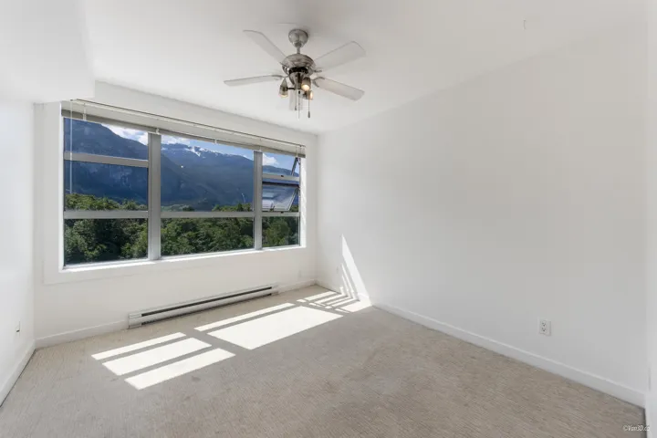 Carpeted spare room with a baseboard heating unit, baseboards, and a ceiling fan