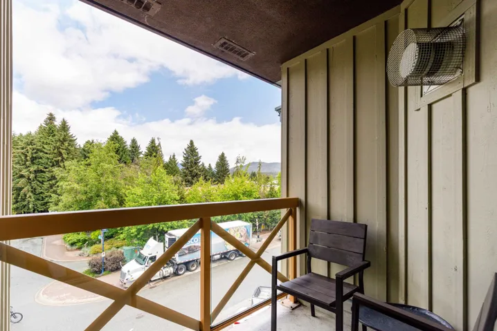 Exterior balcony featuring a wood-finish railing and vertical siding