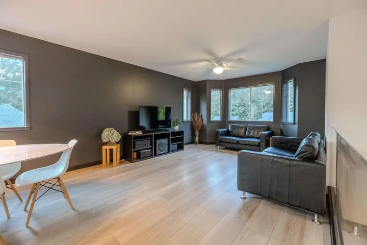 Living room with light wood-style flooring and ceiling fan