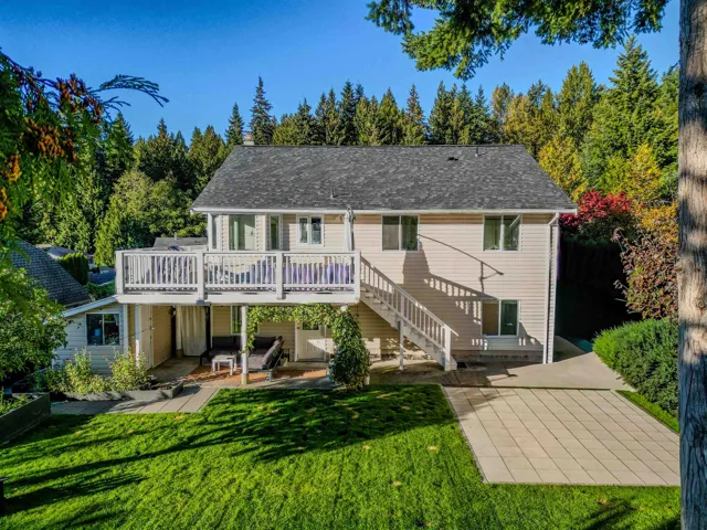 Rear view of property featuring a patio, stairs, a yard, a wooden deck, and view of wooded area