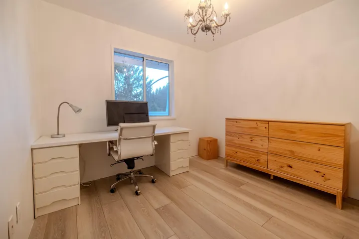 Office space with light wood finished floors and a chandelier