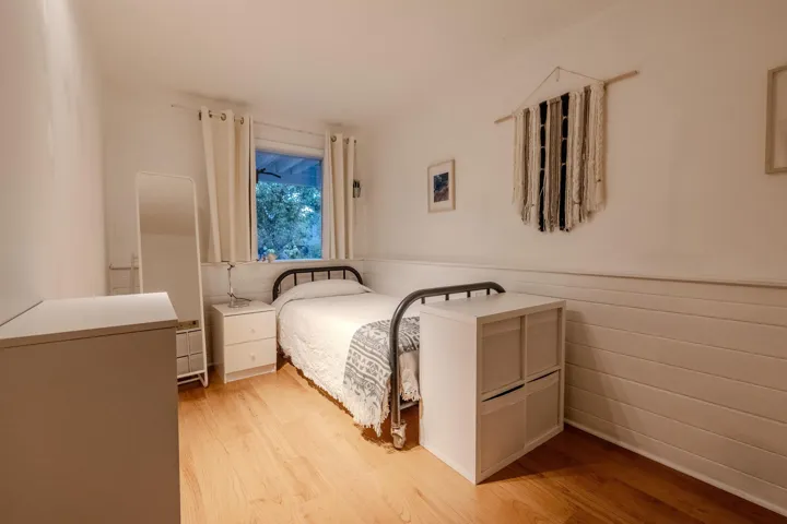 Bedroom featuring a wainscoted wall and light wood-type flooring