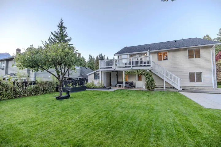 Rear view of house with a patio area, stairway, and a wooden deck