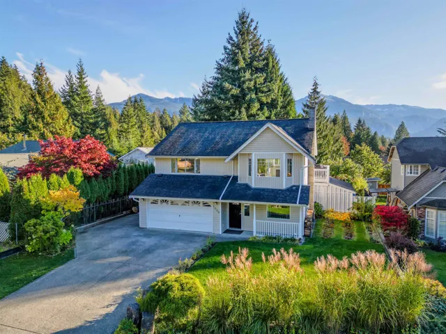 Traditional-style home featuring driveway, covered porch, a mountain view, and a shingled roof