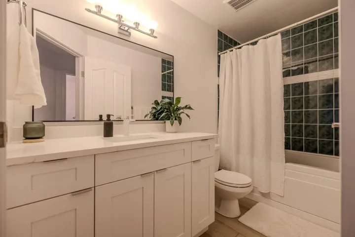 Full bathroom with shower / bath combo with shower curtain and vanity