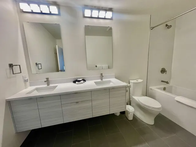 Full bathroom with toilet, double vanity, a sink, and tile patterned flooring