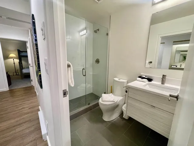 Full bathroom with toilet, a stall shower, vanity, and tile patterned flooring