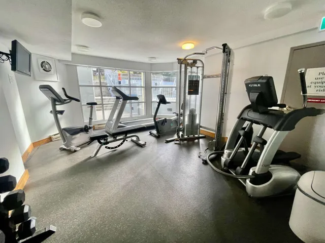 Exercise room featuring baseboards and a textured ceiling