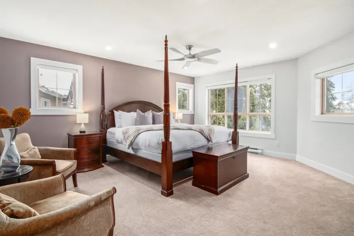 Bedroom with a baseboard radiator, recessed lighting, baseboards, and light carpet
