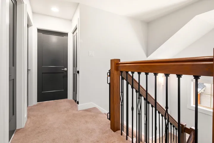 Corridor featuring an upstairs landing, baseboards, and carpet floors