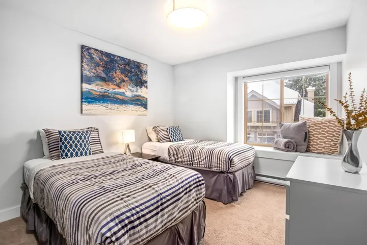 Bedroom featuring light carpet, baseboard heating, and baseboards