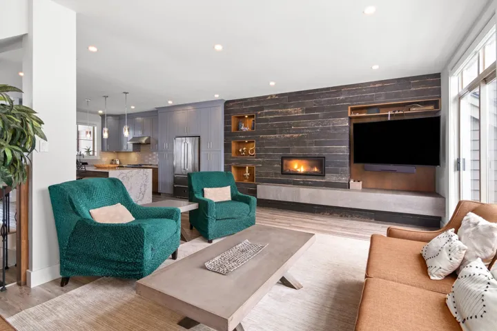 Living room with wood finished floors, wooden walls, recessed lighting, and a large fireplace