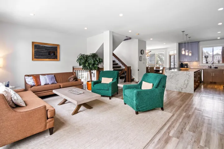 Living room with stairway, recessed lighting, and light wood-style floors