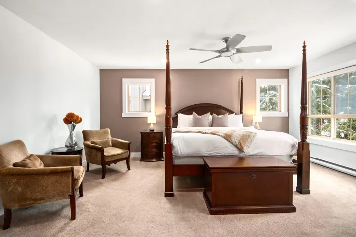 Bedroom with baseboard heating, light colored carpet, and ceiling fan