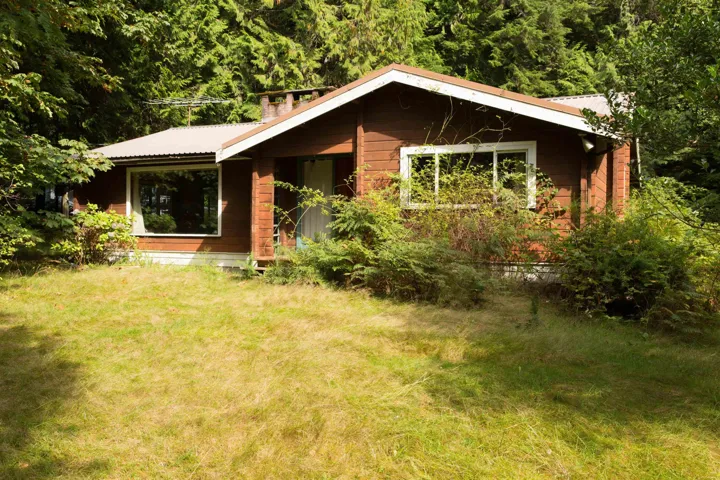 View of front of home with a metal roof and a front yard