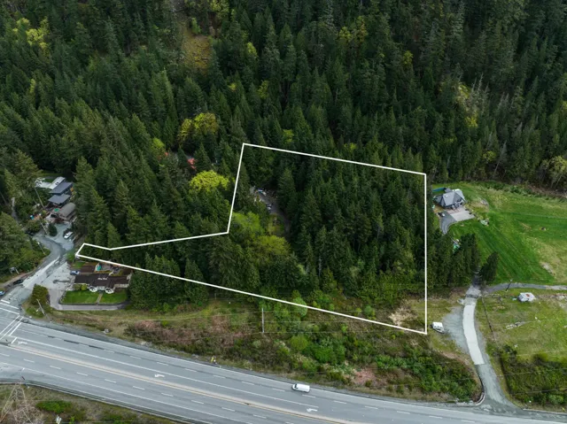 Aerial overview of property's location with property boundaries highlighted and a heavily wooded area