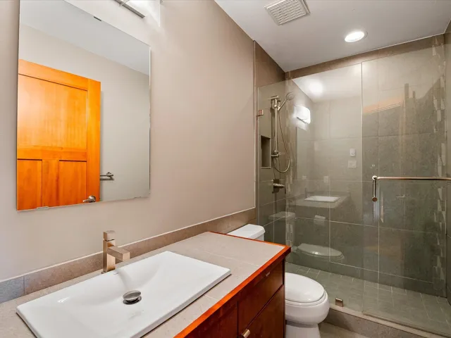 Full bath featuring toilet, vanity, a shower stall, visible vents, and recessed lighting