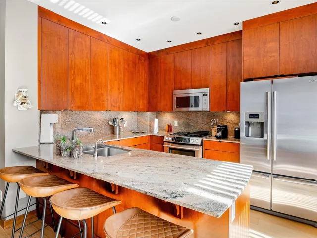 Kitchen featuring a sink, stainless steel appliances, a peninsula, and decorative backsplash