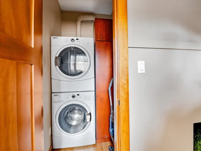Clothes washing area featuring stacked washer and dryer